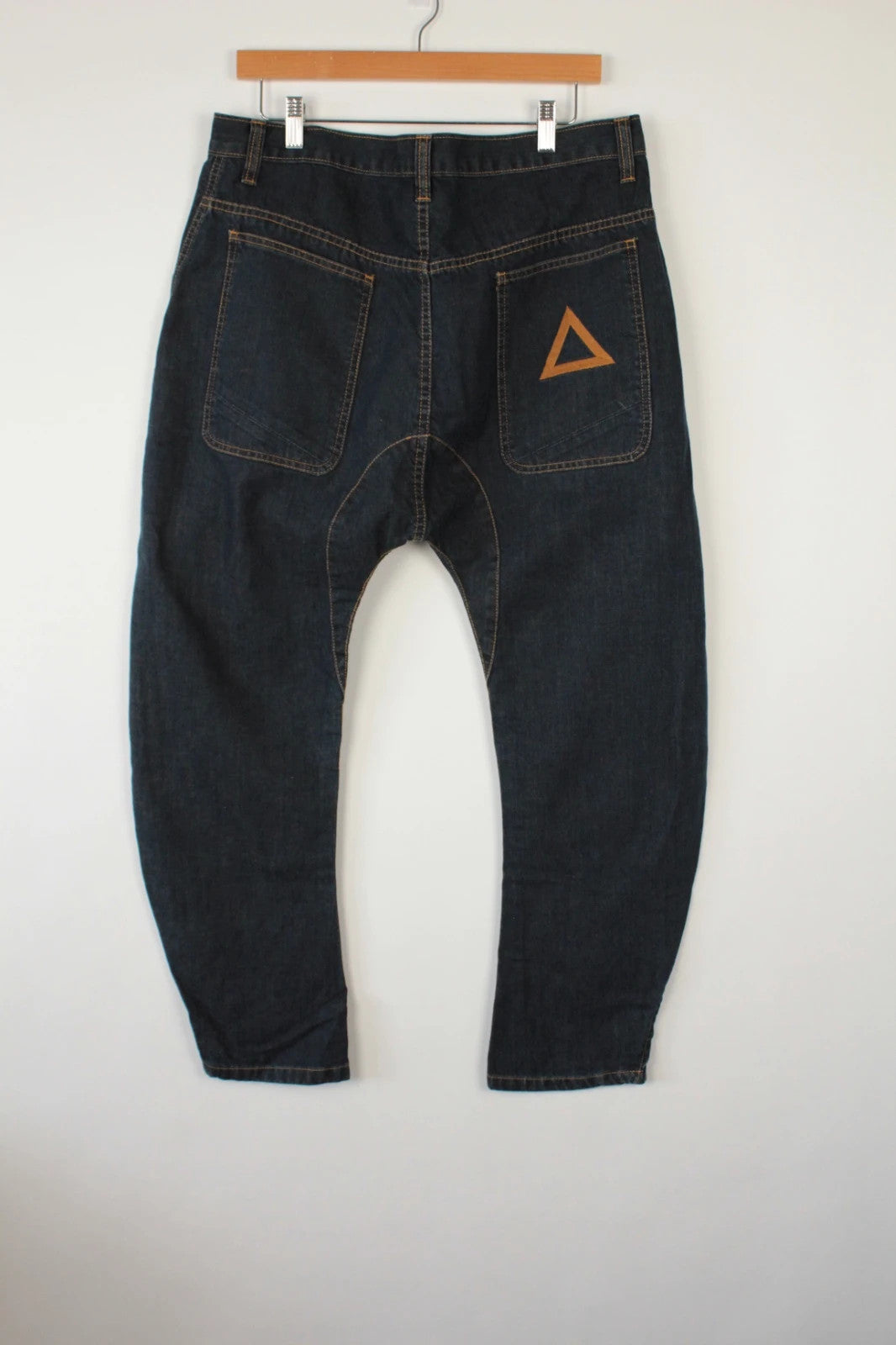 Aqua black and navy wide-leg trousers with tan triangle patch and contrast stitching.