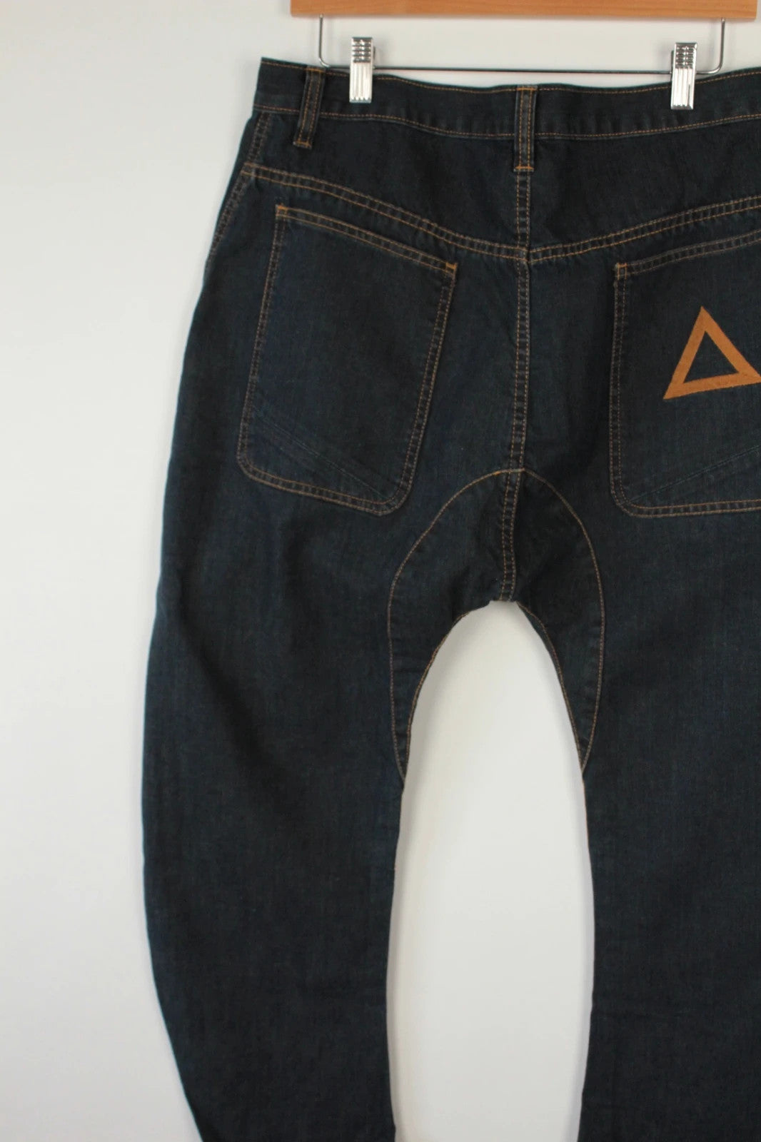 Aqua black and navy wide-leg trousers with tan triangle patch and contrast stitching.