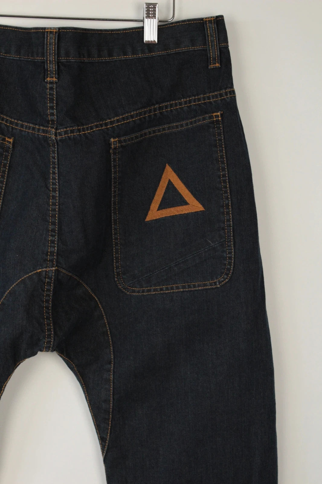 Aqua black and navy wide-leg trousers with tan triangle patch and contrast stitching.