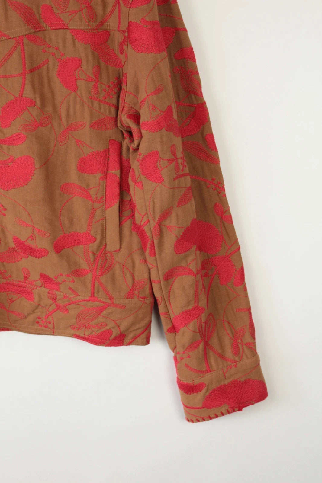 Andersson Bell brown zip-up jacket with vibrant red floral embroidery and logo rivets.