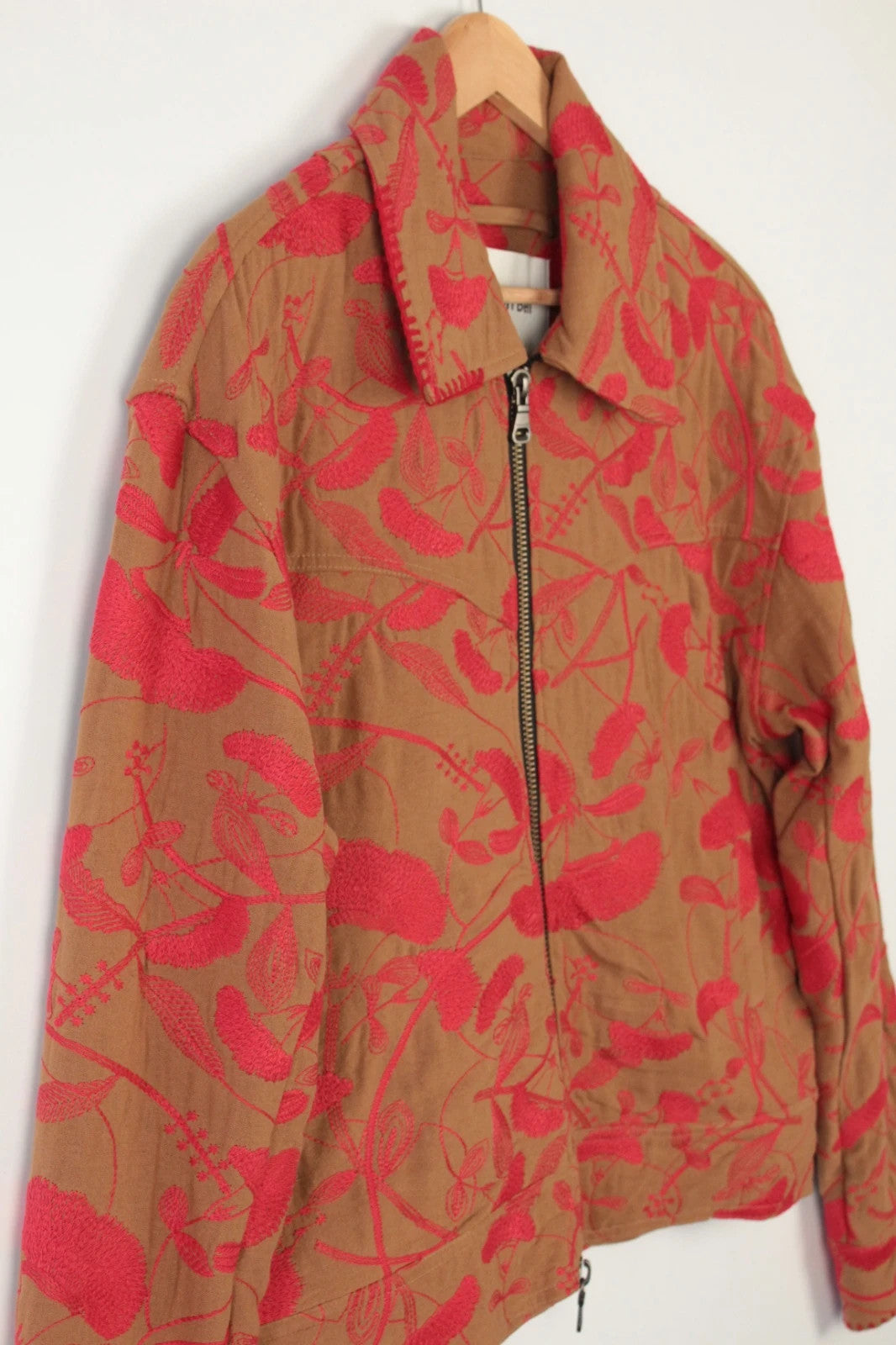 Andersson Bell brown zip-up jacket with vibrant red floral embroidery and logo rivets.