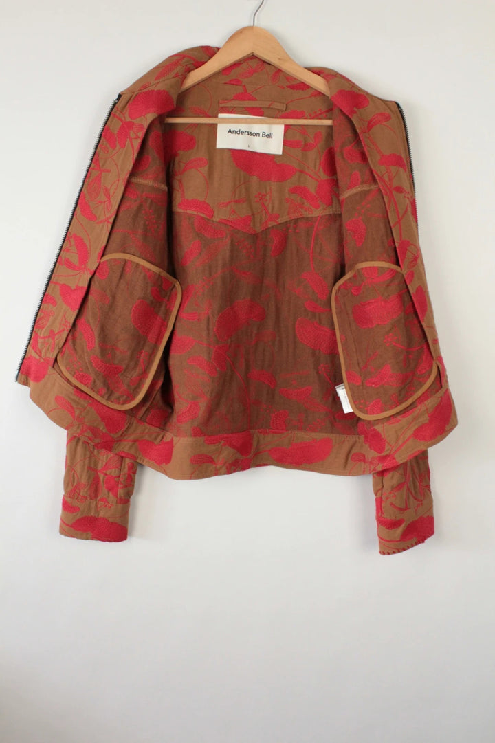 Andersson Bell brown zip-up jacket with vibrant red floral embroidery and logo rivets.