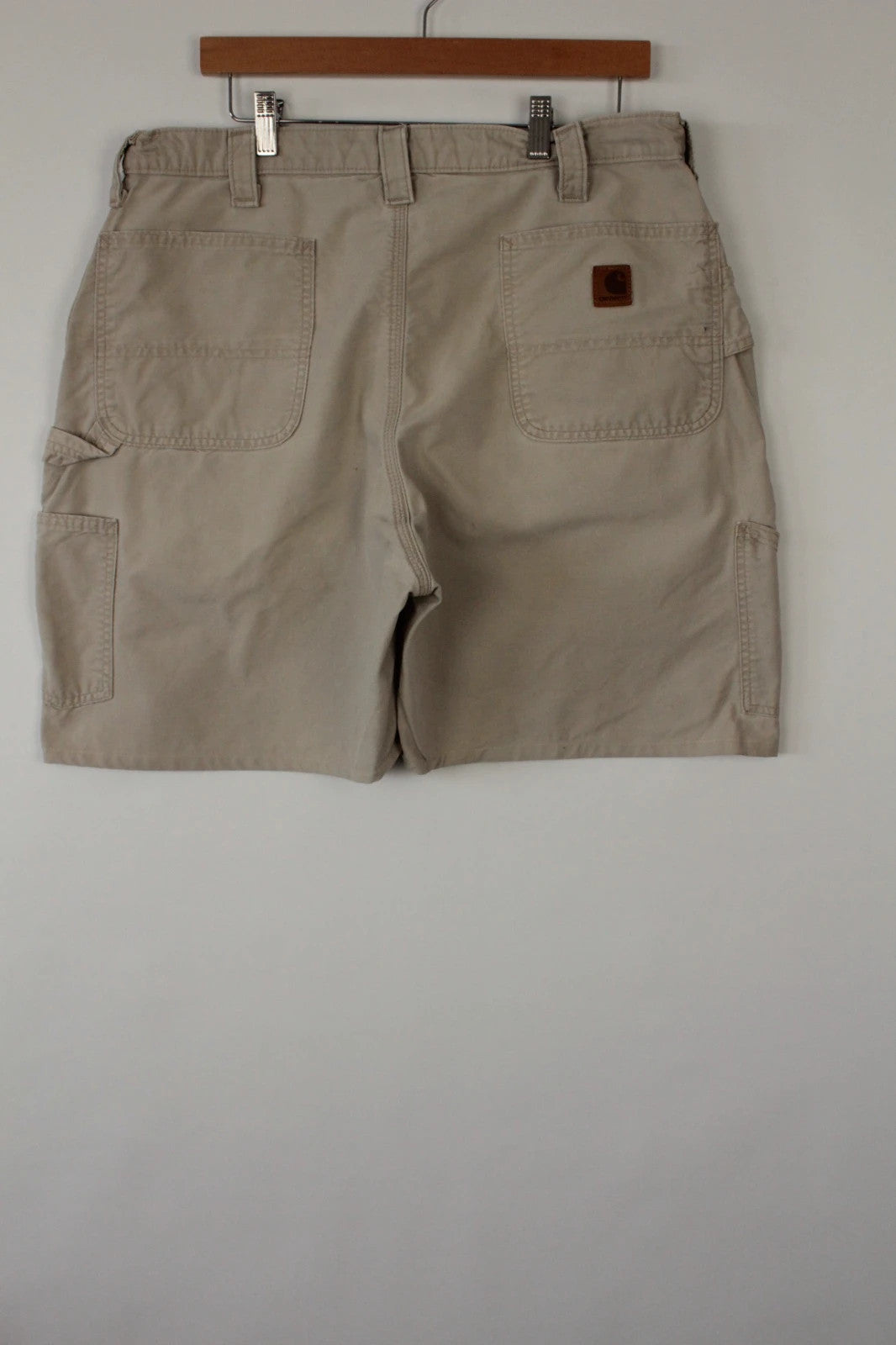 Carhartt beige canvas shorts with drawstring waist and leatherette logo patch.