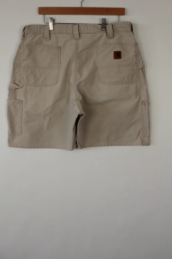 Carhartt beige canvas shorts with drawstring waist and leatherette logo patch.