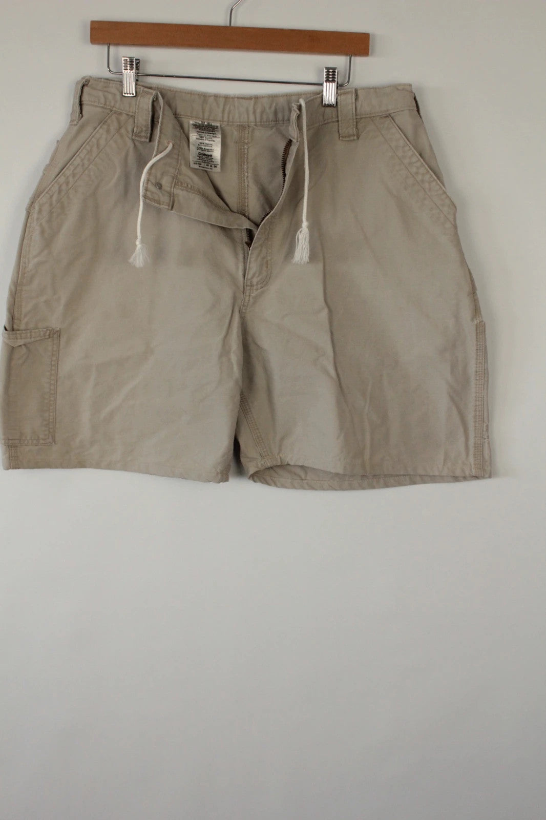 Carhartt beige canvas shorts with drawstring waist and leatherette logo patch.