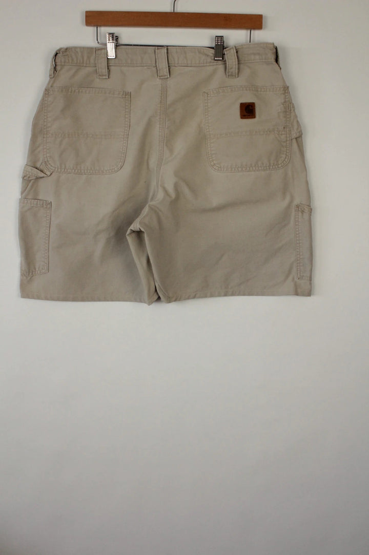 Carhartt beige canvas shorts with drawstring waist and leatherette logo patch.