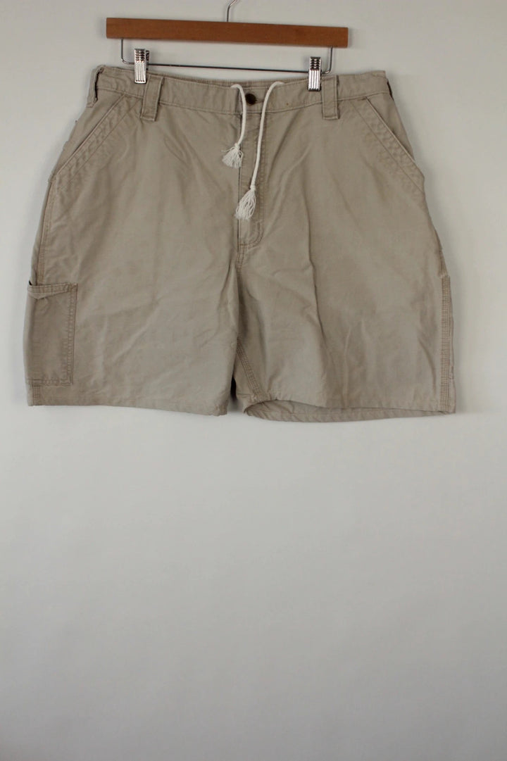 Carhartt beige canvas shorts with drawstring waist and leatherette logo patch.