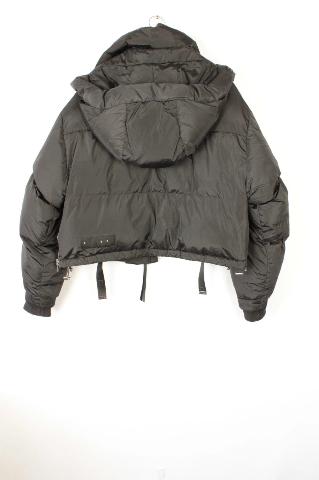 Shoreditch Ski Club black cropped puffer jacket with quilted matte shell and harness straps.