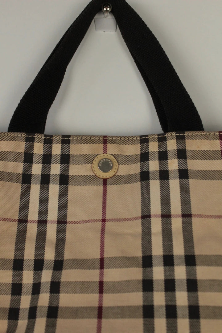 Burberry beige Nova Check tote bag with black trim and gold embossed logo plate.