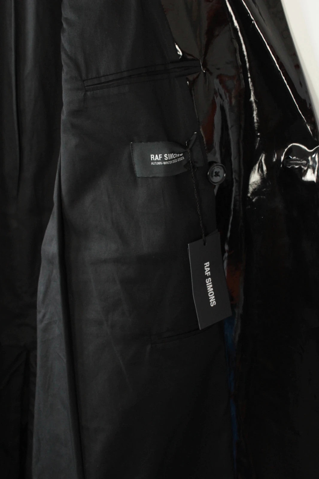 Raf Simons black double-breasted trench coat glossy PVC finish with notched lapels.