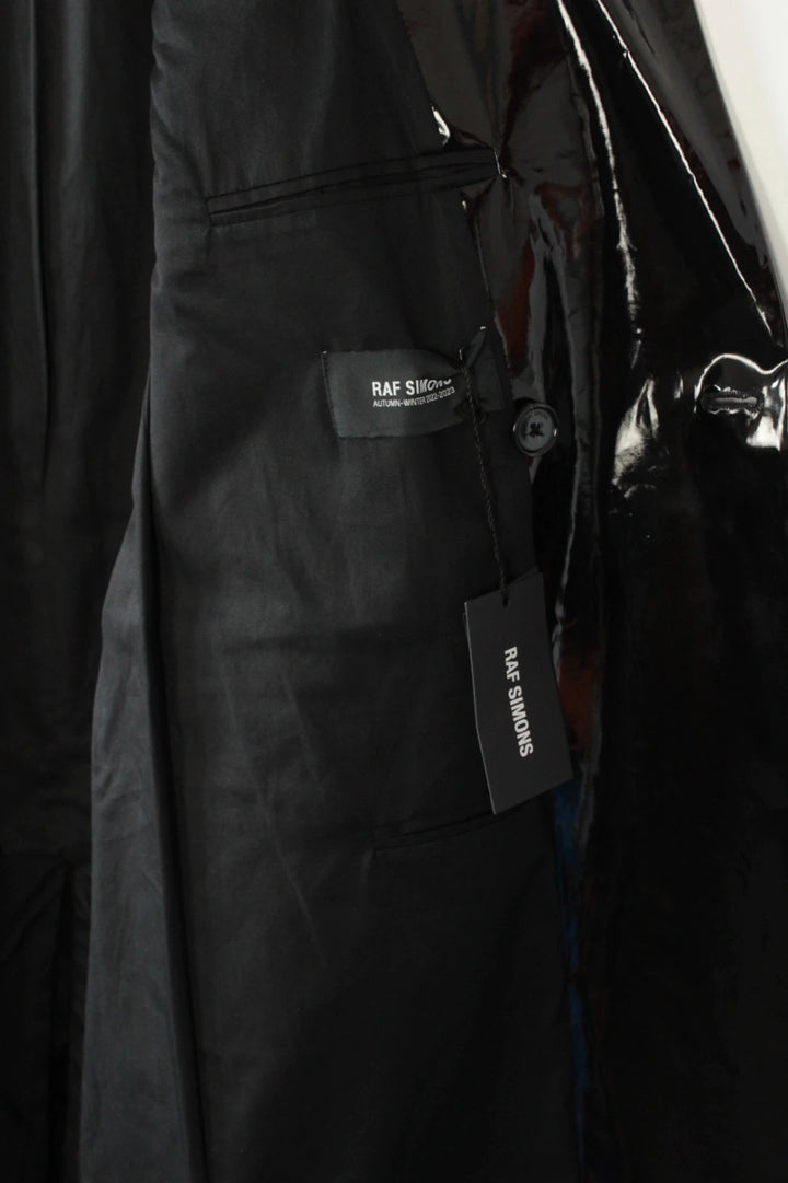 Raf Simons black double-breasted trench coat glossy PVC finish with notched lapels.
