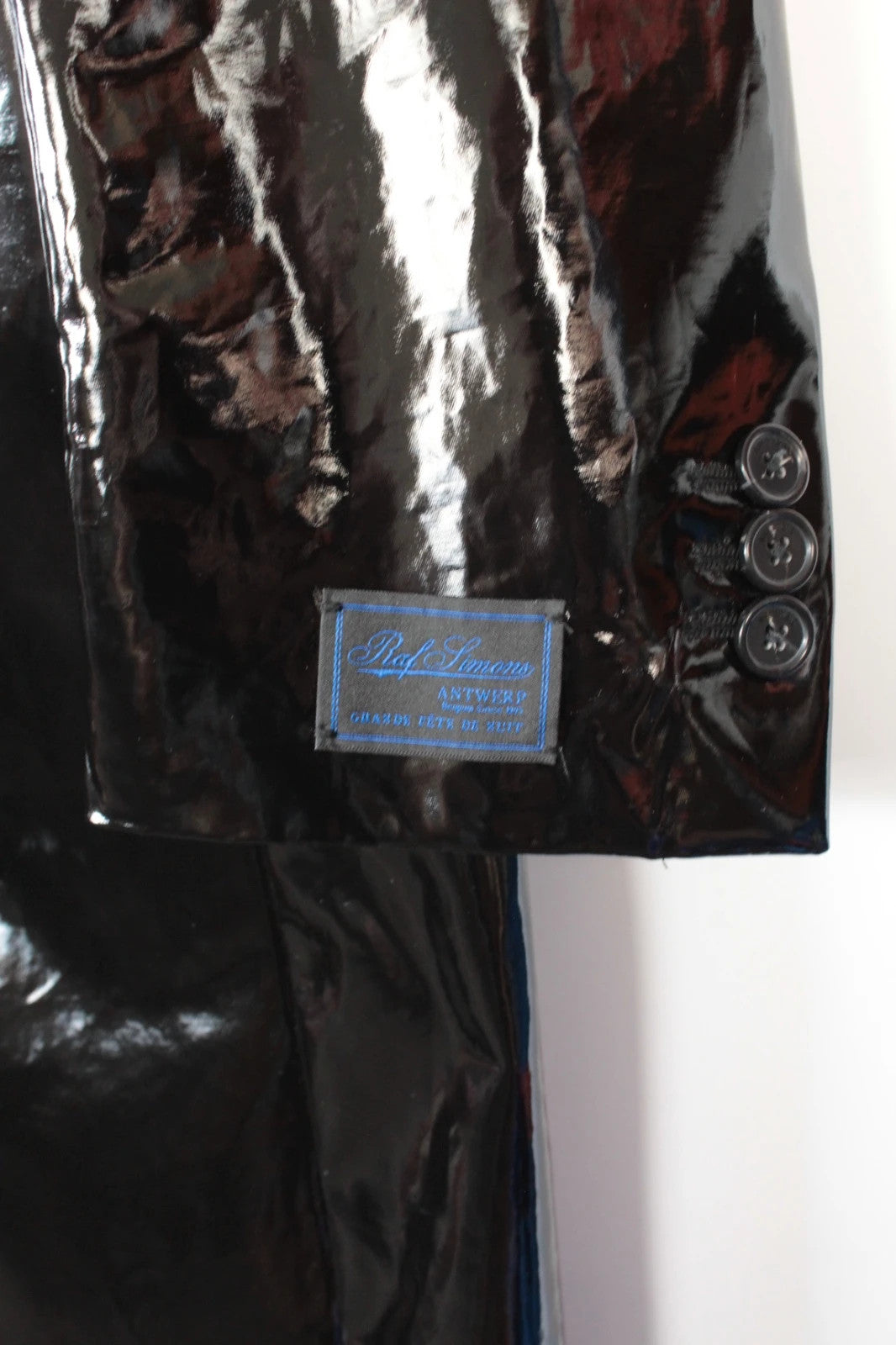 Raf Simons black double-breasted trench coat glossy PVC finish with notched lapels.