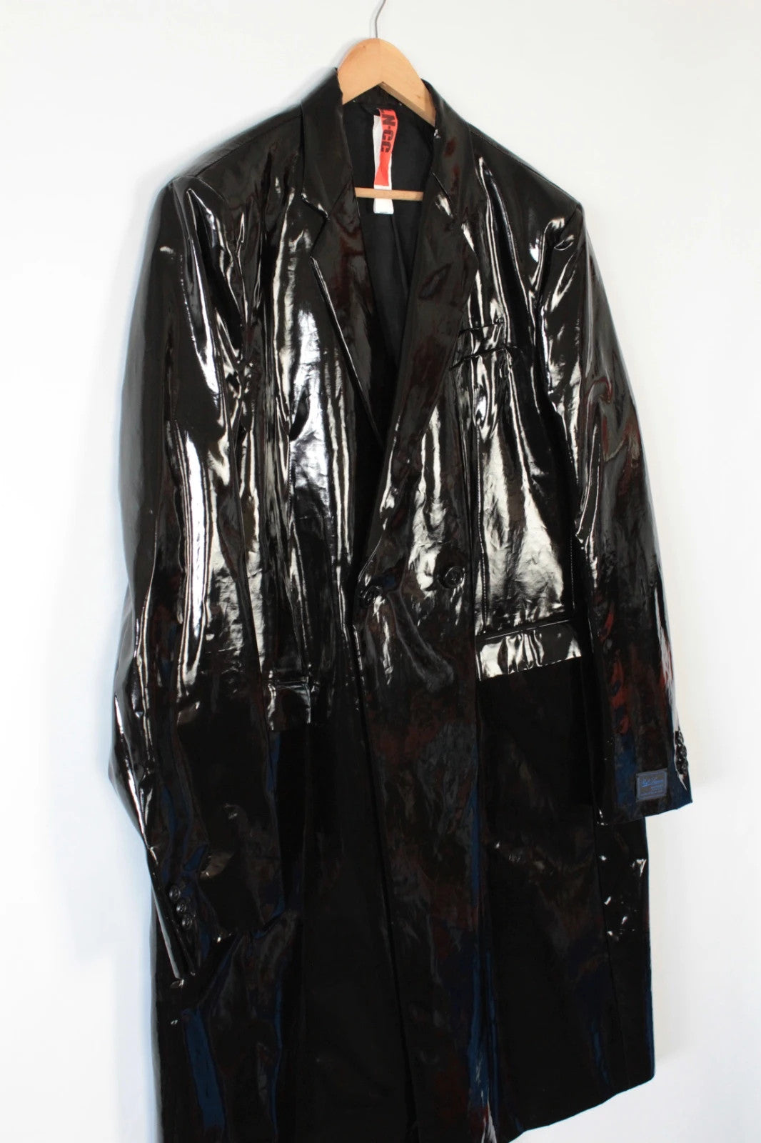 Raf Simons black double-breasted trench coat glossy PVC finish with notched lapels.