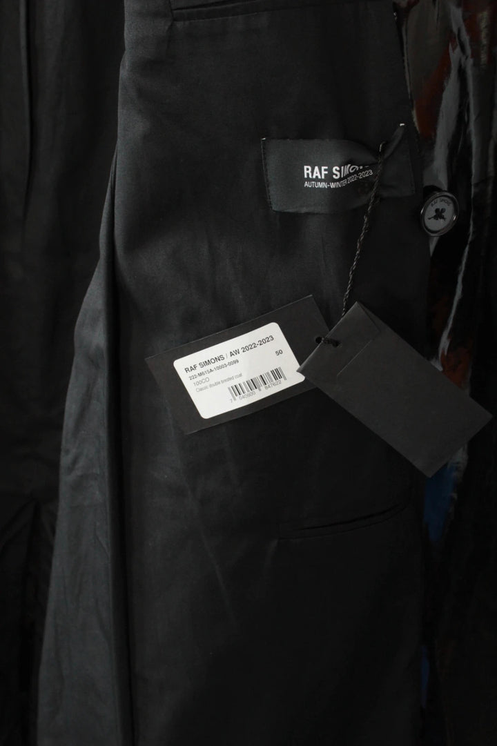 Raf Simons black double-breasted trench coat glossy PVC finish with notched lapels.