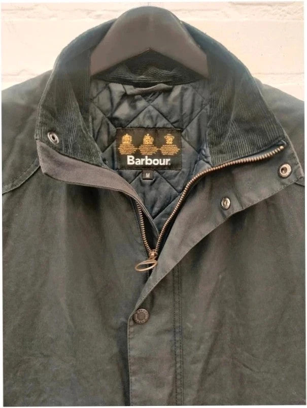 Barbour navy blouson wax jacket with quilted lining and Levi's denim pocket details.
