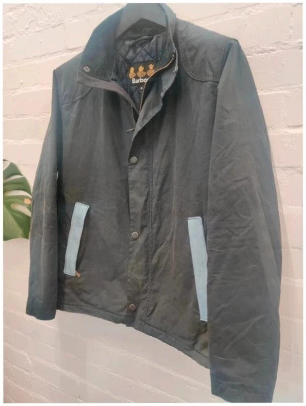 Barbour navy blouson wax jacket with quilted lining and Levi's denim pocket details.
