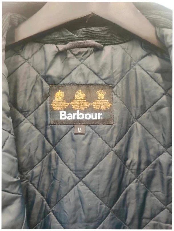 Barbour navy blouson wax jacket with quilted lining and Levi's denim pocket details.