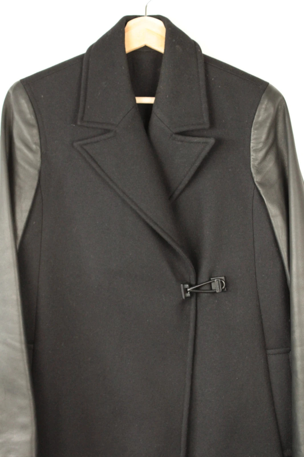 AllSaints black coat with lamb leather sleeves and industrial metal hook buckle fastener.