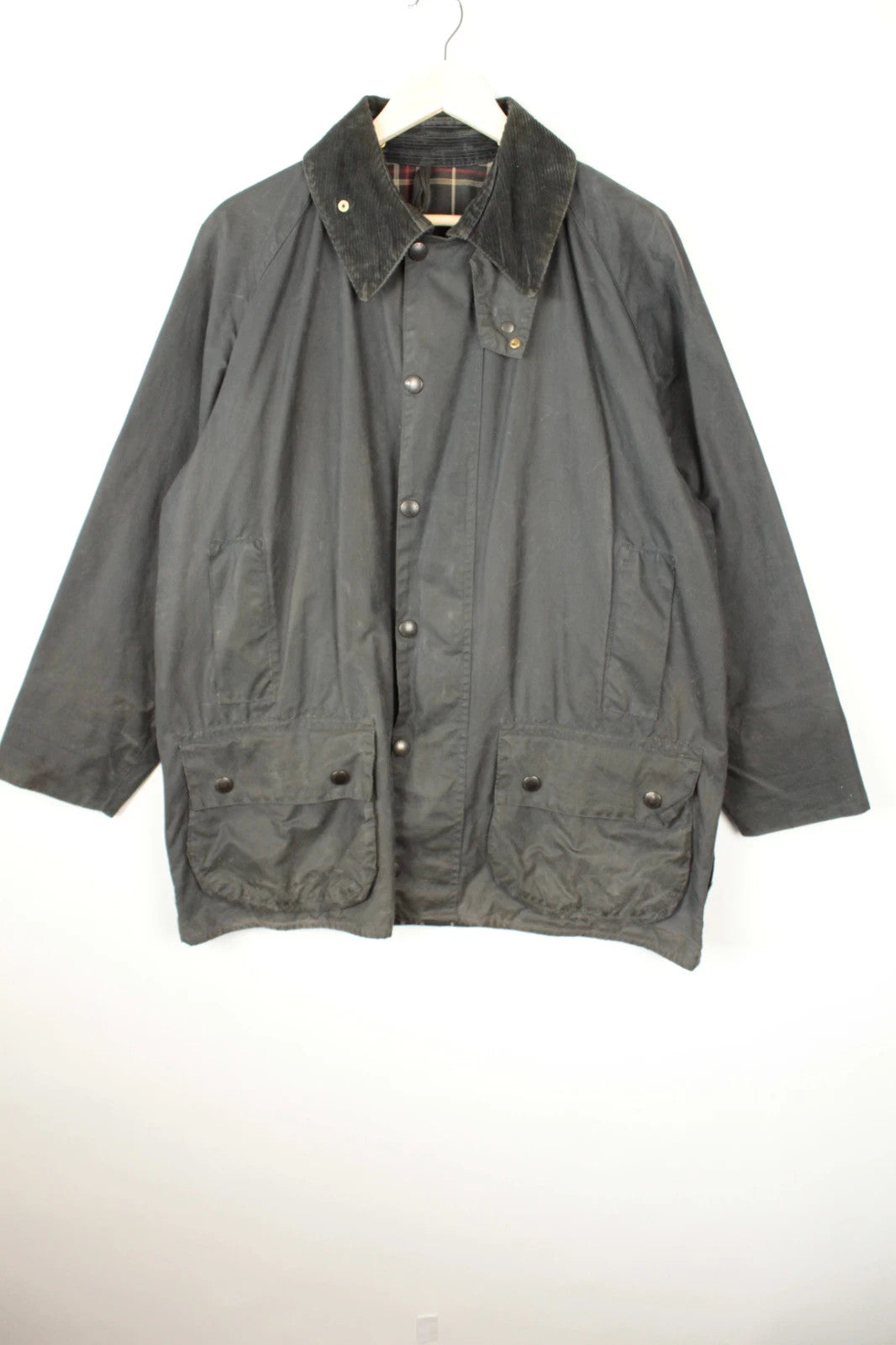Barbour black and navy waxed cotton jacket with corduroy collar and Levi's patchwork details.