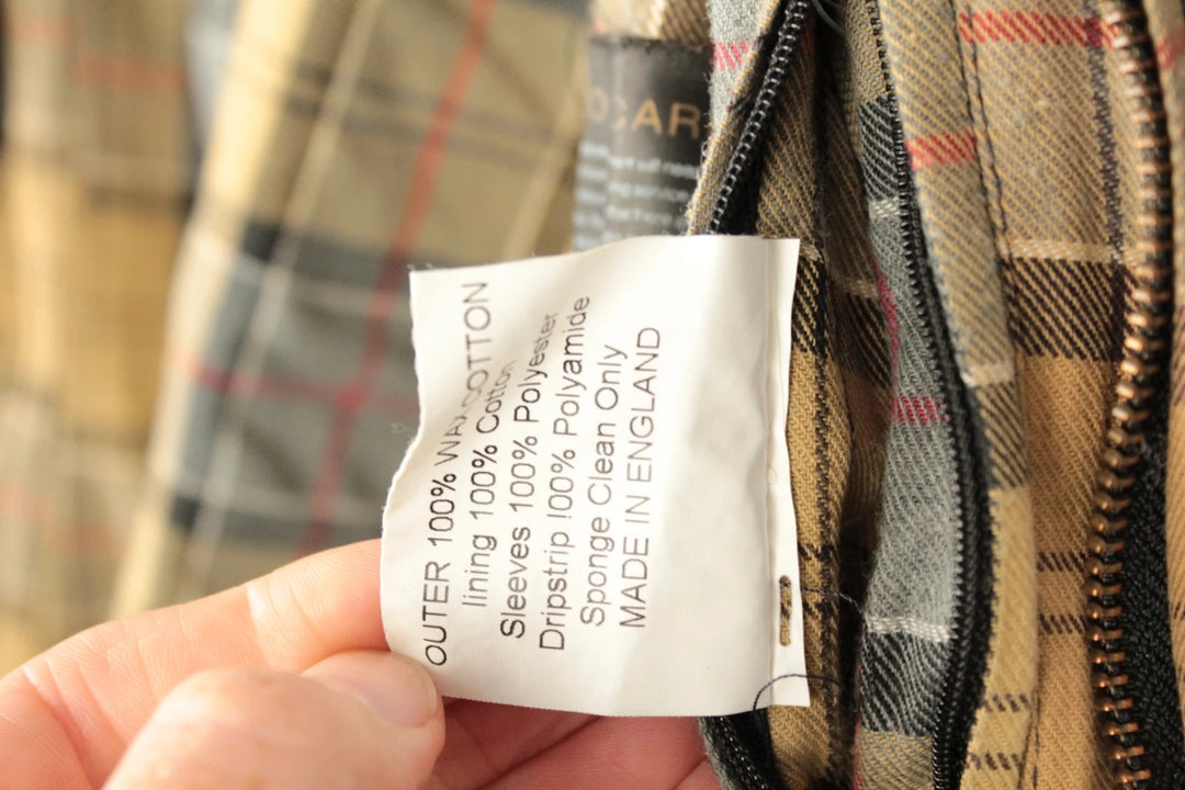 Barbour grey navy waxed cotton jacket with tartan lining and corduroy collar.