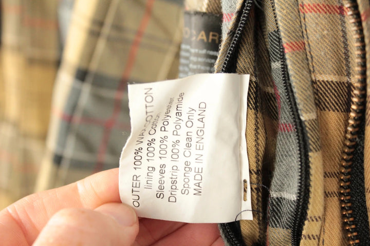 Barbour grey navy waxed cotton jacket with tartan lining and corduroy collar.