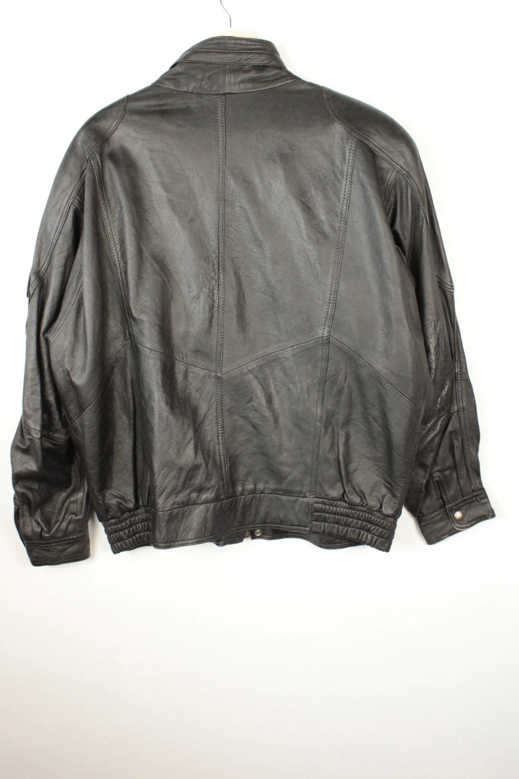 Vintage Dressing black leather bomber jacket with geometric panel stitching and multi-pocket design.