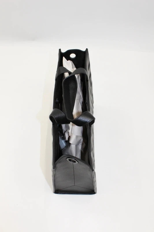 MSCHF black leather tote bag with embossed geometric lettering and dual top handles.