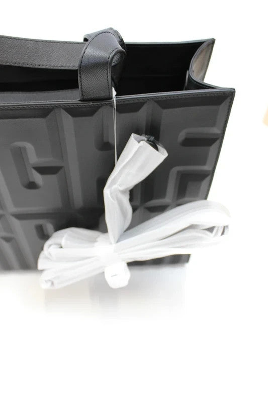 MSCHF black leather tote bag with embossed geometric lettering and dual top handles.