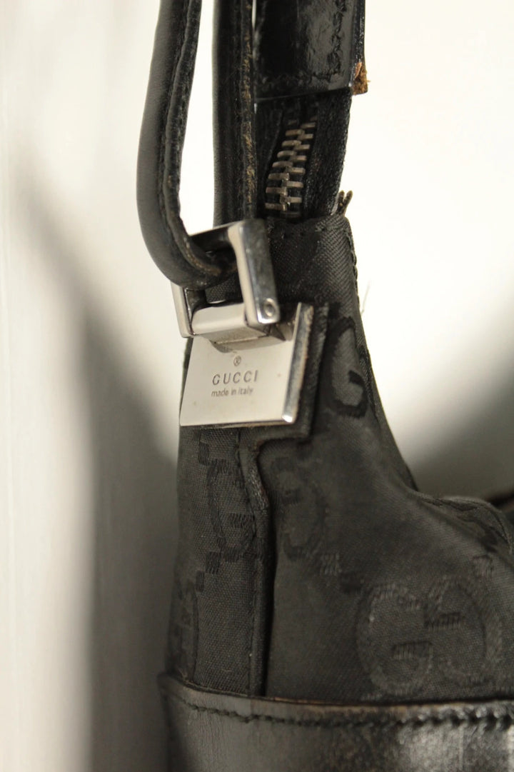 Gucci black hobo bag with GG monogram canvas, calf leather trim, and silver-tone hardware.