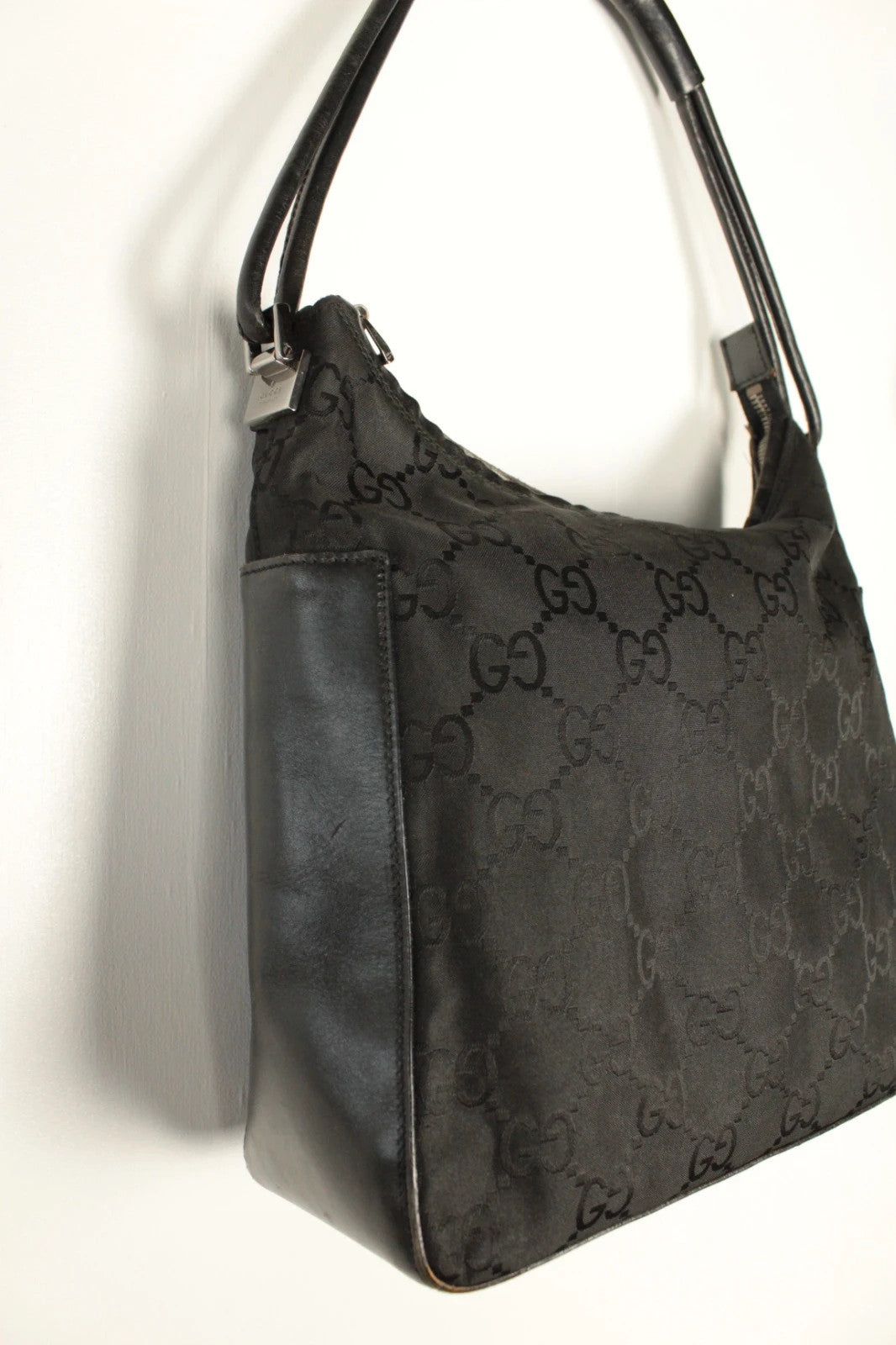Gucci black hobo bag with GG monogram canvas, calf leather trim, and silver-tone hardware.