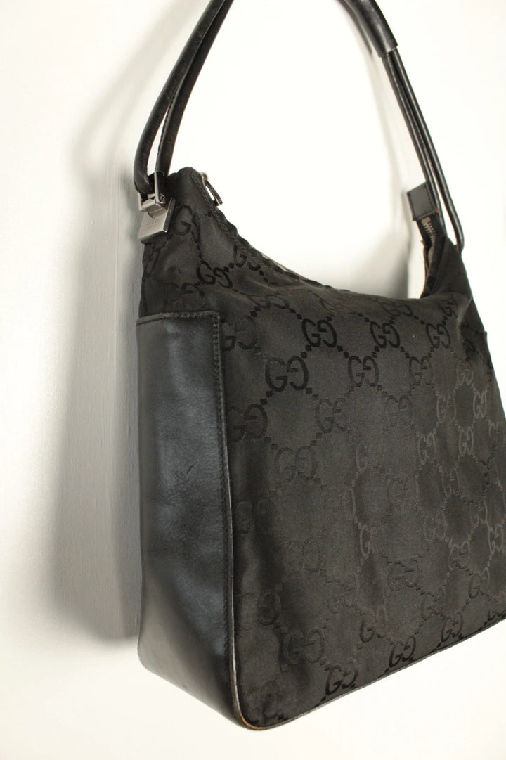 Gucci black hobo bag with GG monogram canvas, calf leather trim, and silver-tone hardware.