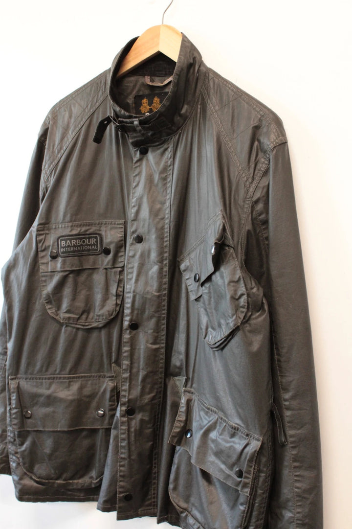 Barbour black waxed utility jacket with Gucci leather accents and multi-pocket design.