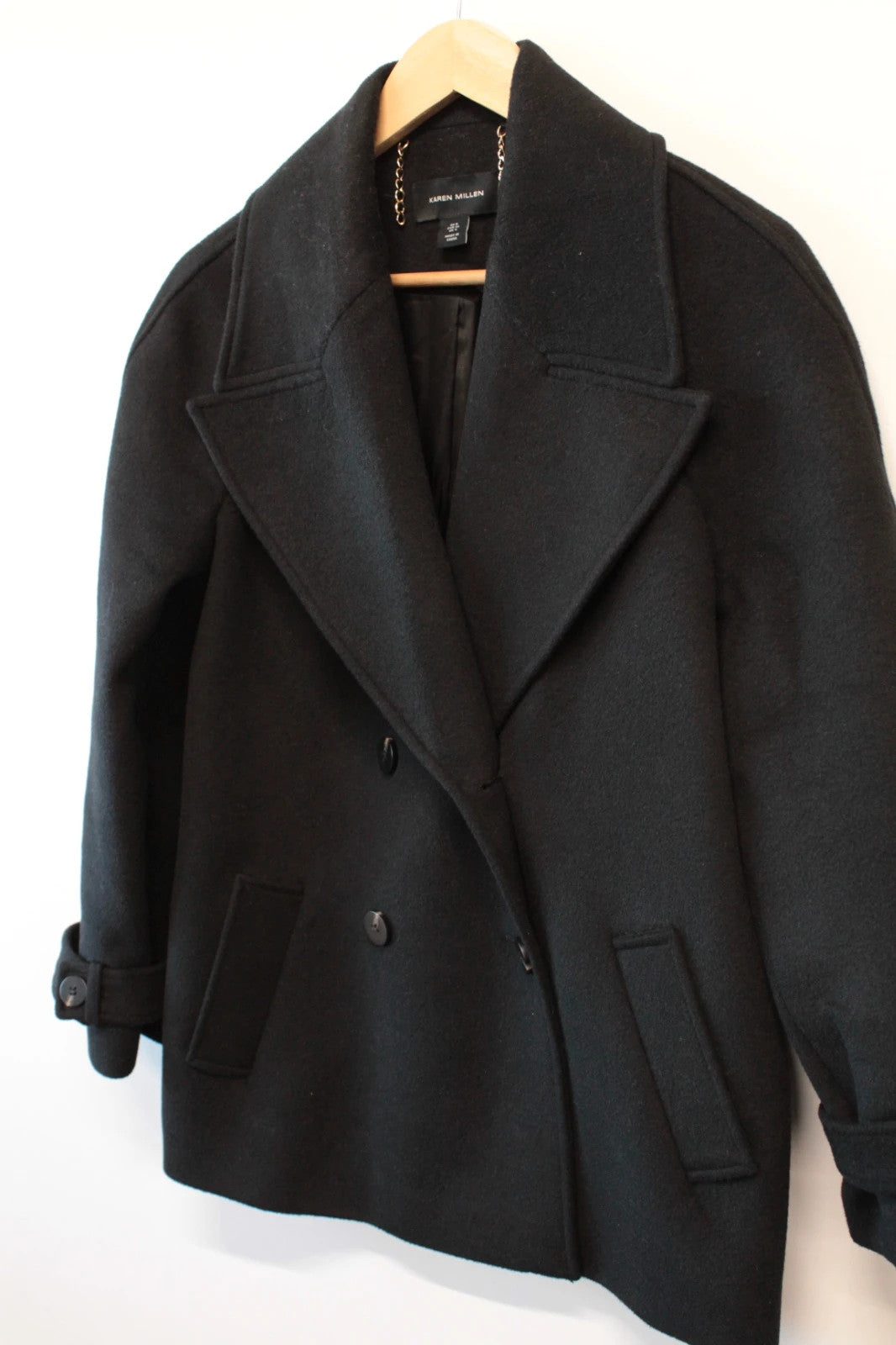 Karen Millen black double-breasted pea coat with tailored silhouette and gold hanging chain.