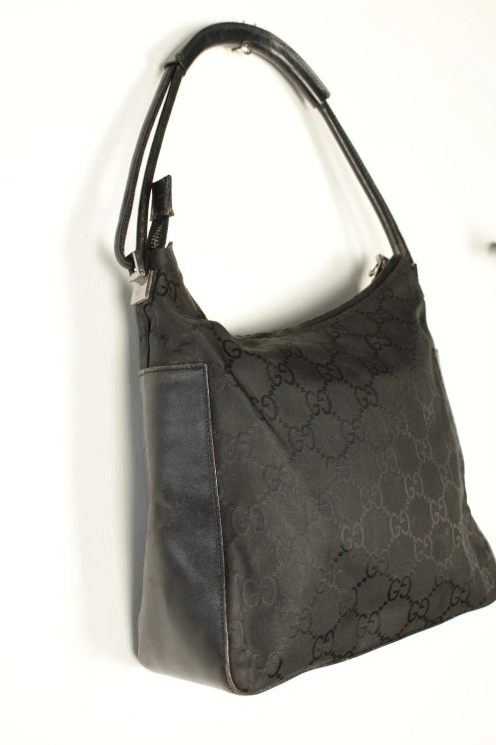Gucci black hobo bag with GG monogram canvas, calf leather trim, and silver-tone hardware.