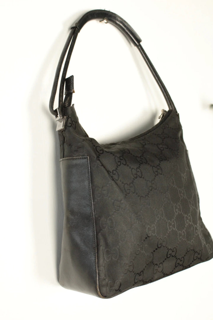 Gucci black hobo bag with GG monogram canvas, calf leather trim, and silver-tone hardware.
