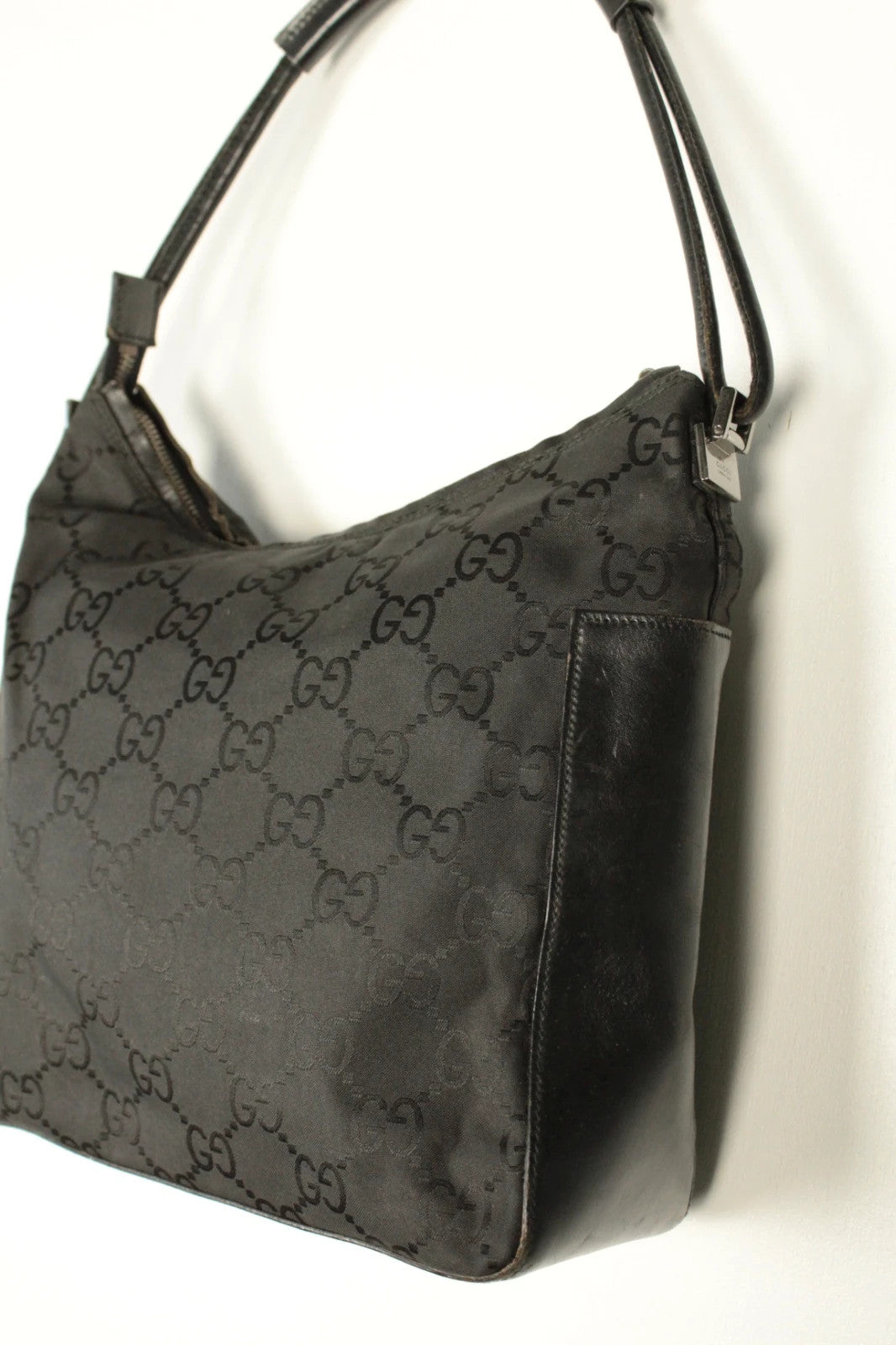 Gucci black hobo bag with GG monogram canvas, calf leather trim, and silver-tone hardware.