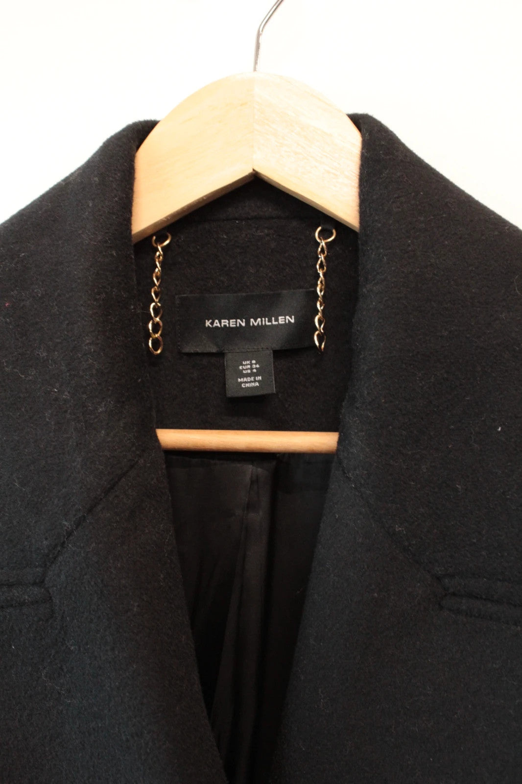 Karen Millen black double-breasted pea coat with tailored silhouette and gold hanging chain.