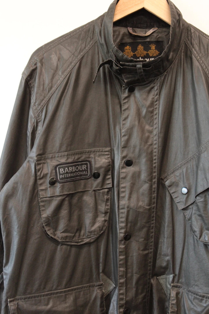 Barbour black waxed utility jacket with Gucci leather accents and multi-pocket design.