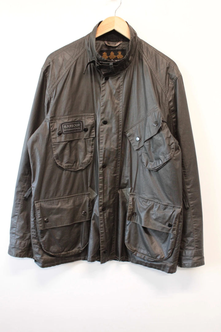 Barbour black waxed utility jacket with Gucci leather accents and multi-pocket design.