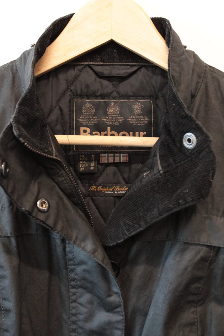 Barbour black waxed cotton jacket with tartan pattern and corduroy collar accent.