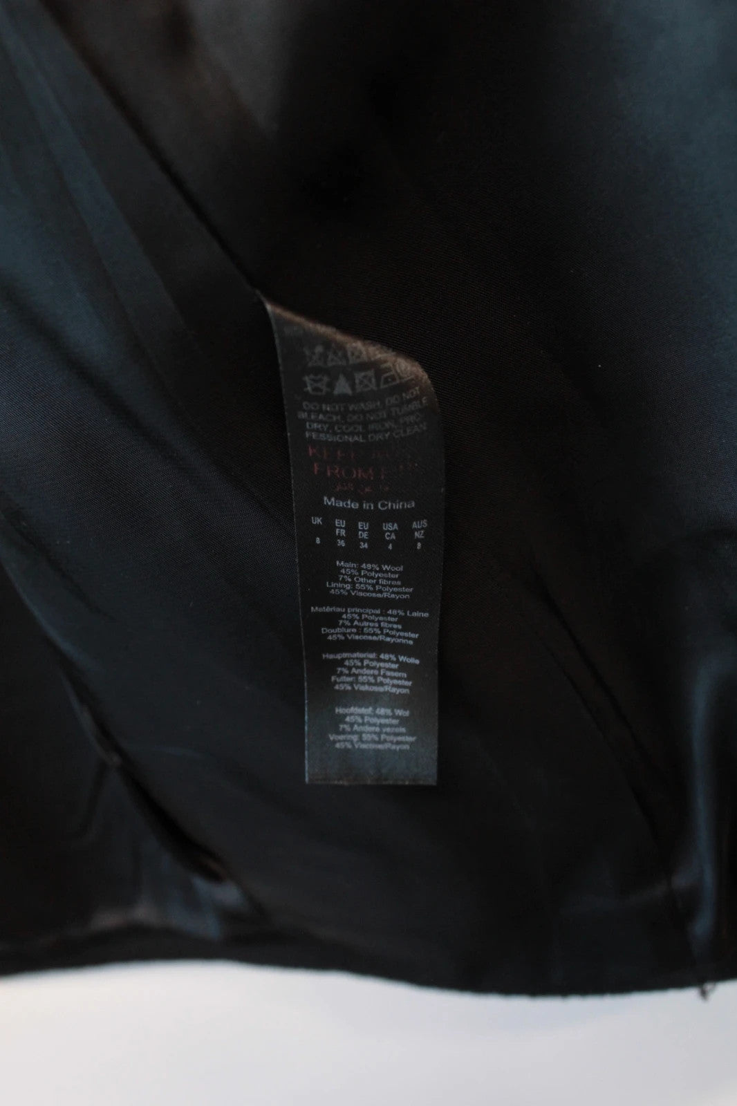 Karen Millen black double-breasted pea coat with tailored silhouette and gold hanging chain.