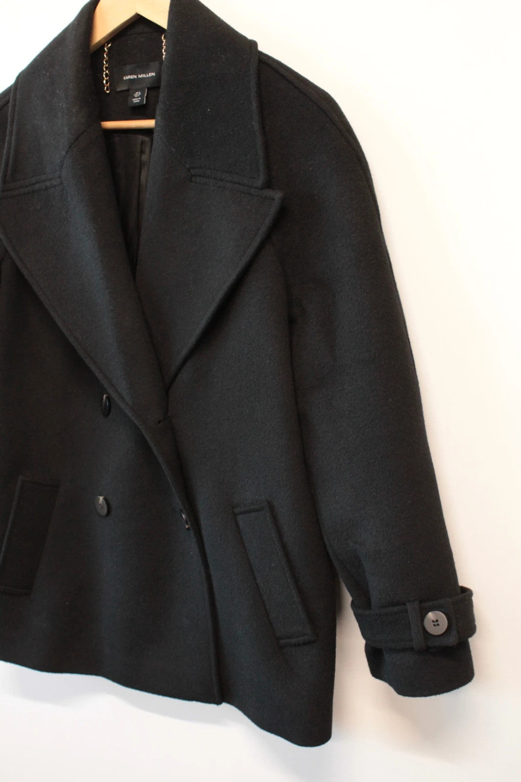Karen Millen black double-breasted pea coat with tailored silhouette and gold hanging chain.