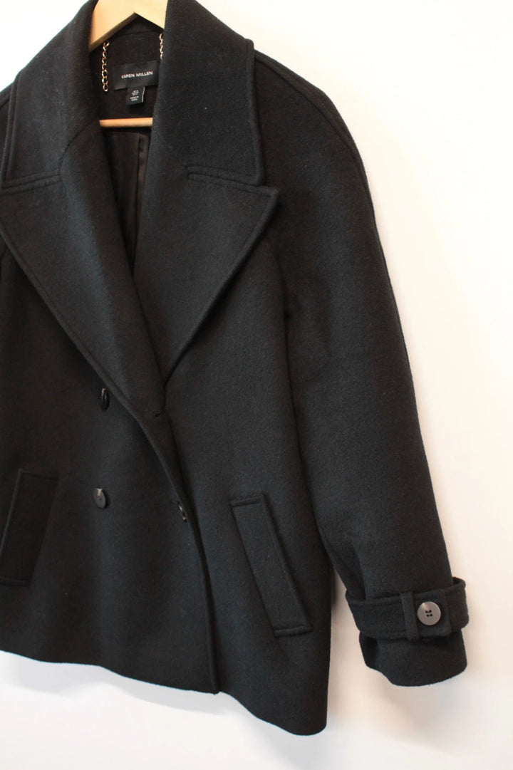 Karen Millen black double-breasted pea coat with tailored silhouette and gold hanging chain.
